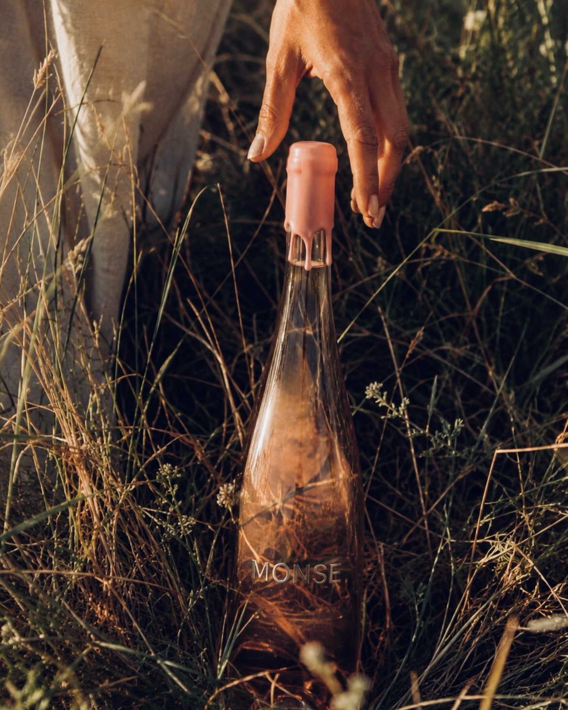 MONSE bottle in tall grass at golden hour