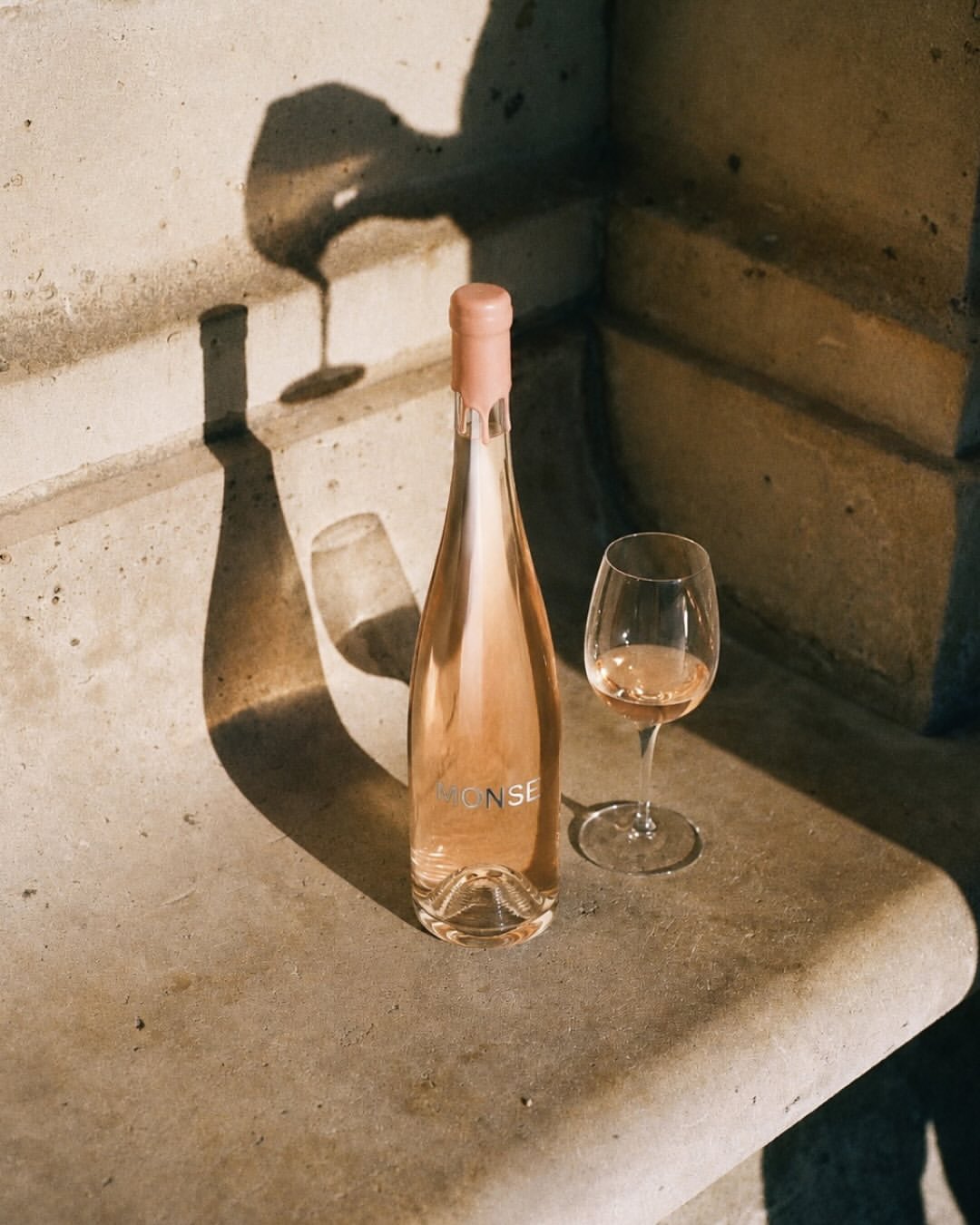 MONSE bottle and glass on a stone bench